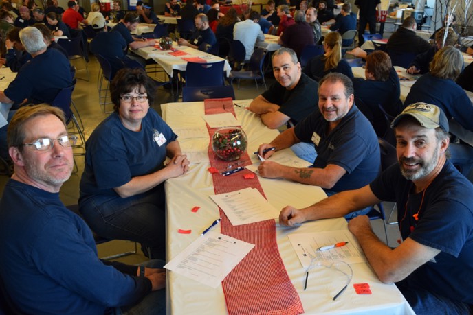 Employees sitting at cafeteria tables with holiday decor