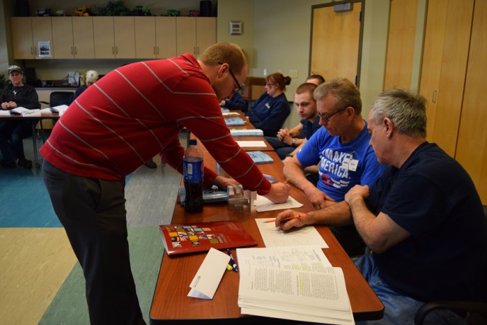 Kondex team members sitting at tables with training materials