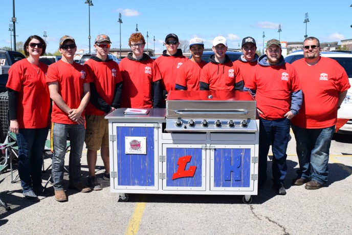 Project grill students standing behind grill